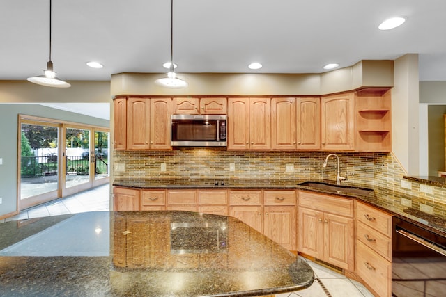 kitchen with black electric stovetop, sink, hanging light fixtures, dark stone countertops, and tasteful backsplash