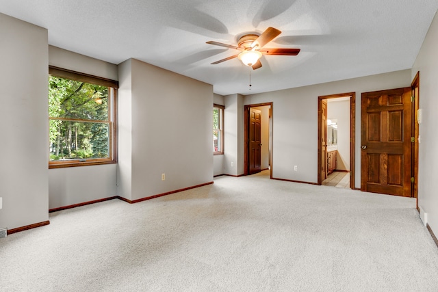 carpeted spare room featuring ceiling fan and a textured ceiling