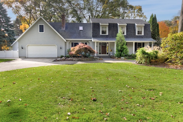 new england style home featuring a front lawn and a garage