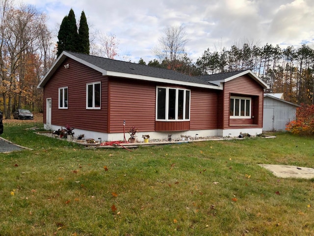 rear view of property featuring a lawn