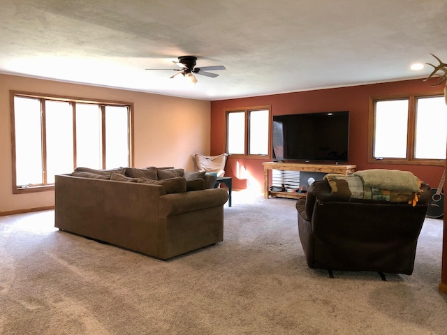 living room with ceiling fan, light carpet, and a wealth of natural light