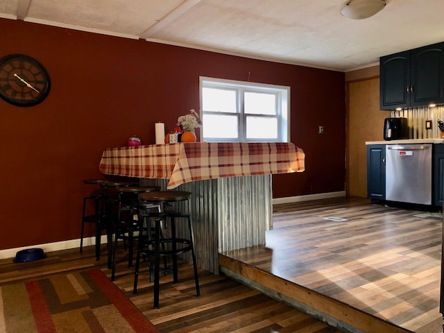 kitchen featuring stainless steel dishwasher and dark hardwood / wood-style flooring