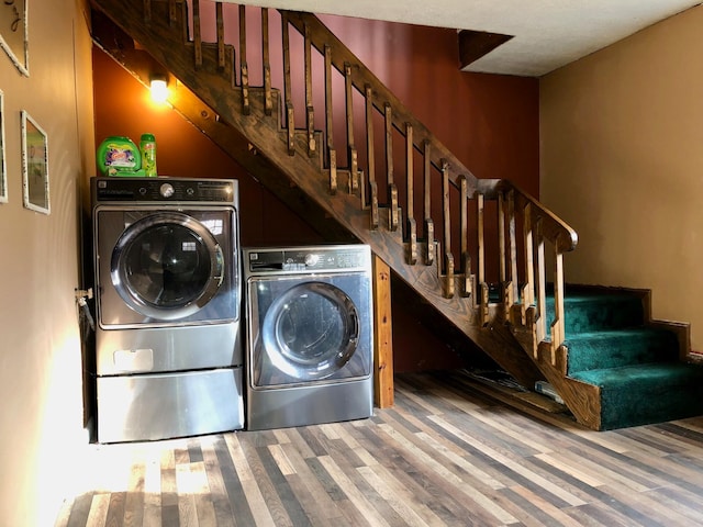 clothes washing area featuring washer and dryer and wood-type flooring