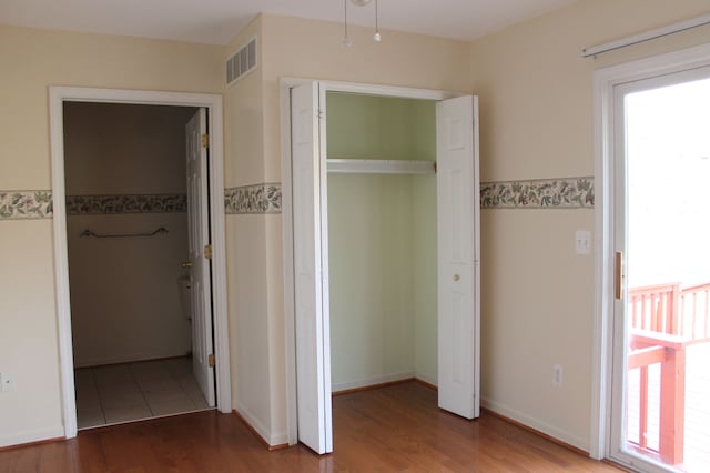 unfurnished bedroom featuring wood-type flooring and a closet