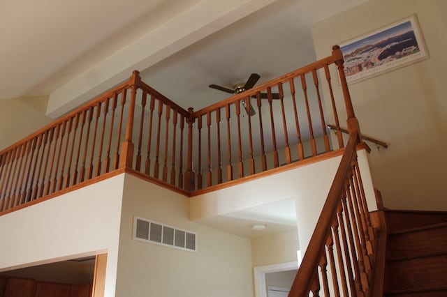 staircase with ceiling fan and a towering ceiling