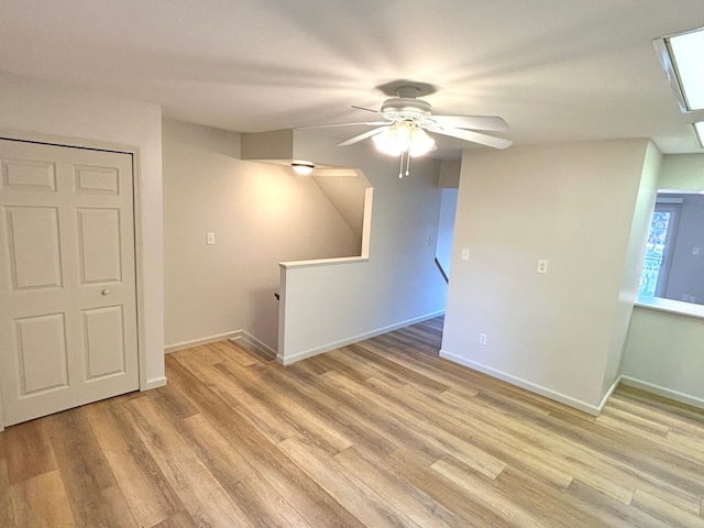 spare room with ceiling fan and light wood-type flooring