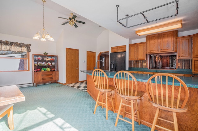 kitchen featuring sink, black fridge, vaulted ceiling, light carpet, and ceiling fan with notable chandelier