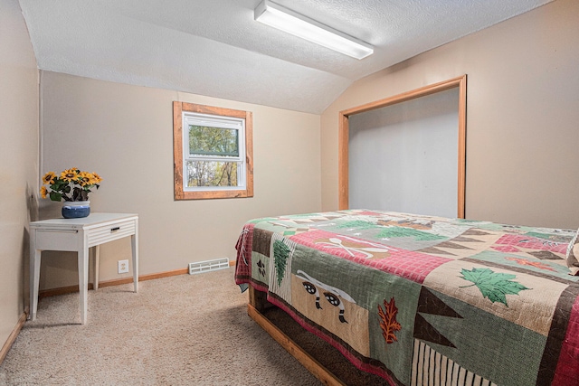 bedroom with carpet, a textured ceiling, and lofted ceiling