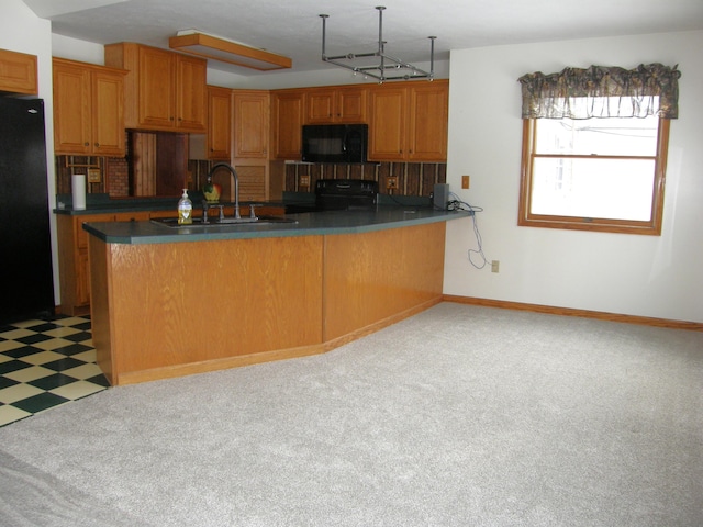 kitchen featuring light floors, black appliances, a peninsula, and brown cabinetry