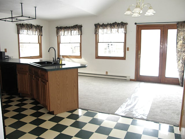 kitchen featuring lofted ceiling, a sink, dark countertops, a notable chandelier, and baseboard heating