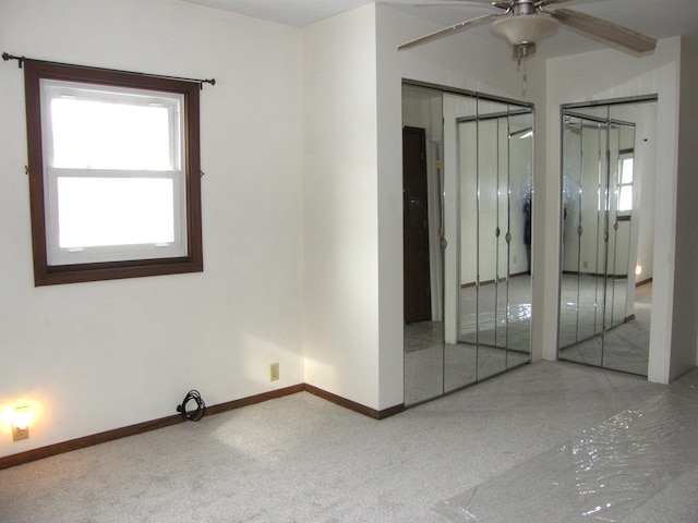 carpeted spare room with ceiling fan