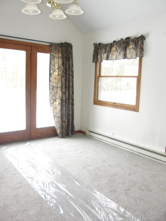 empty room with carpet flooring, a baseboard radiator, and lofted ceiling