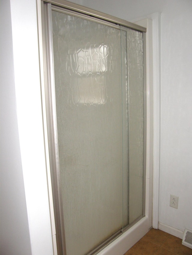 bathroom with tile patterned floors and an enclosed shower