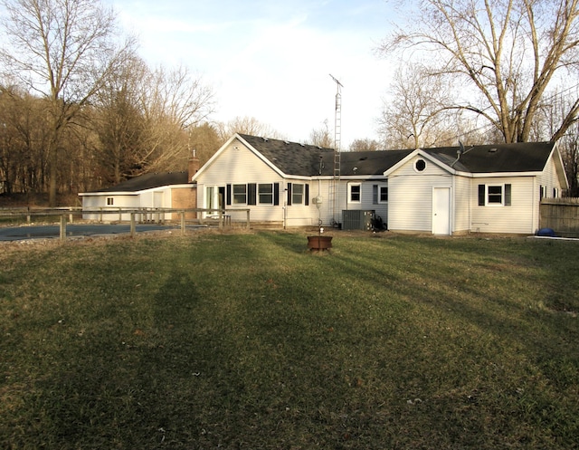 back of house with a yard, fence, and central AC