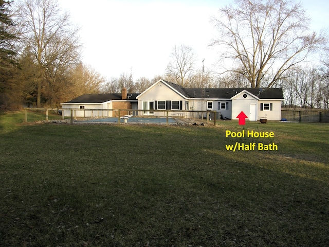 back of property featuring a yard and fence