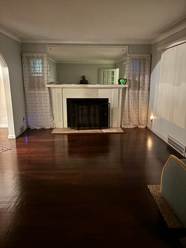 unfurnished living room featuring ornamental molding and hardwood / wood-style flooring