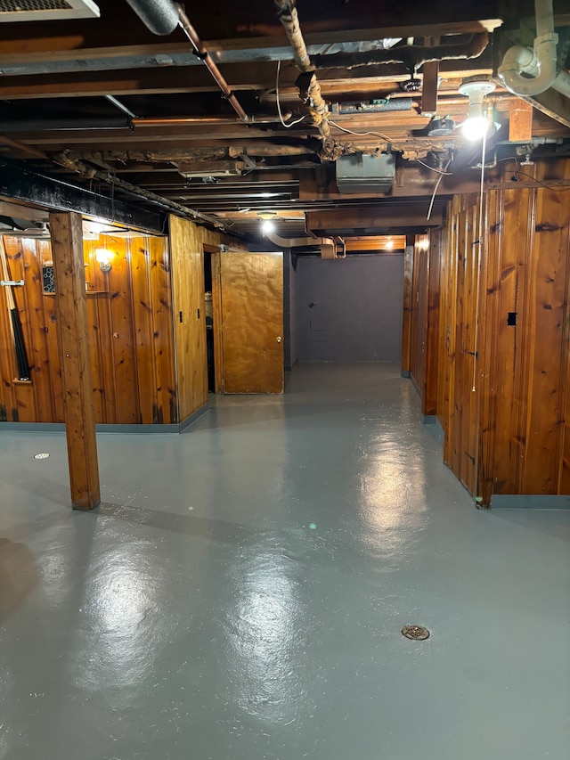 basement featuring wood walls