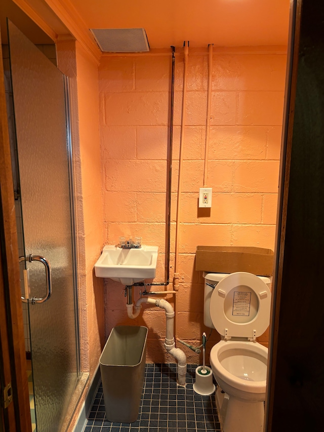 bathroom with sink, tile patterned floors, and brick wall