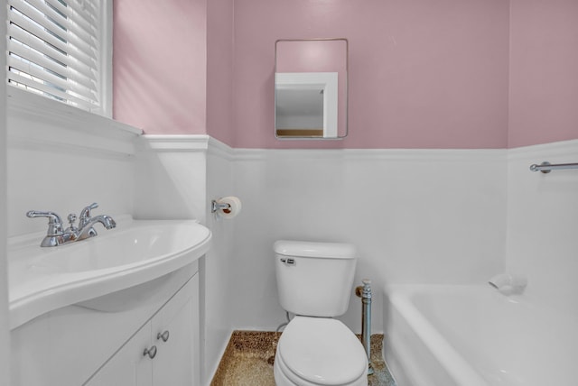 bathroom with vanity, a bathtub, and toilet