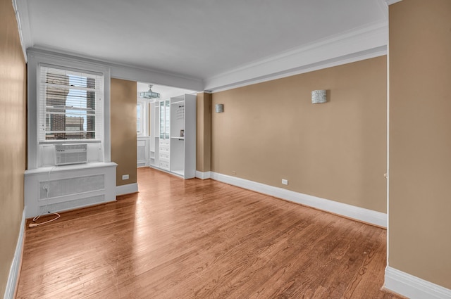 unfurnished living room with wood-type flooring, cooling unit, ornamental molding, and radiator