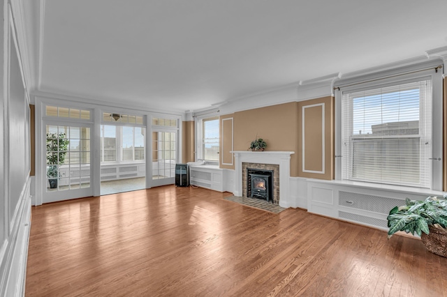 unfurnished living room with wood-type flooring and ornamental molding