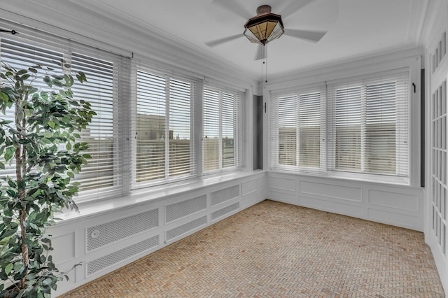 unfurnished sunroom with ceiling fan