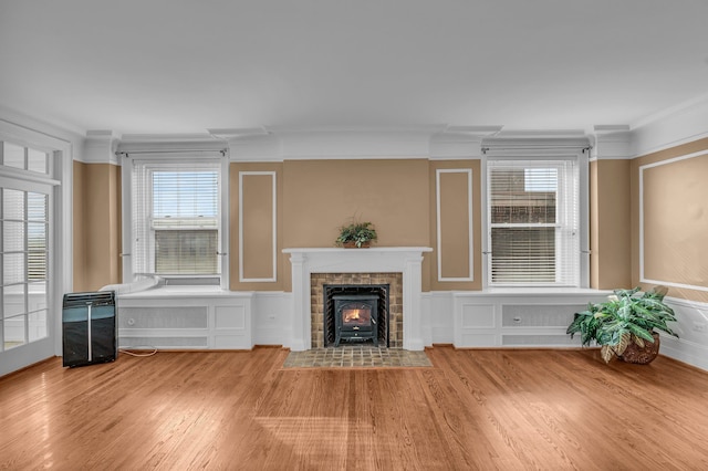 unfurnished living room featuring wood-type flooring and ornamental molding