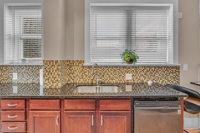 kitchen with dark stone counters, backsplash, sink, and stainless steel dishwasher