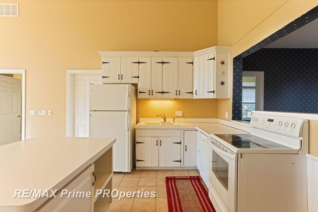 10300 Lange Rd, Birch Run, MI 48415 - kitchen featuring white appliances, a sink, light countertops, white cabinets, and a high ceiling