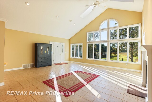 10300 Lange Rd, Birch Run, MI 48415 - unfurnished living room featuring high vaulted ceiling, ceiling fan, light tile patterned floors, and baseboards