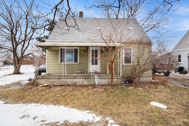 bungalow-style house featuring a lawn and covered porch