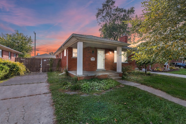 view of front of property with a porch and a yard