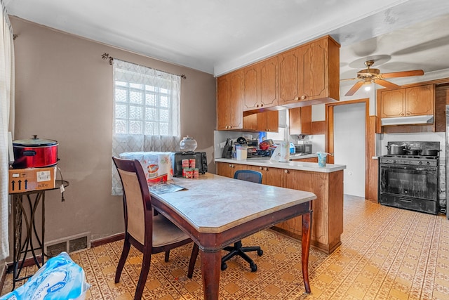 kitchen with ceiling fan, gas stove, and kitchen peninsula