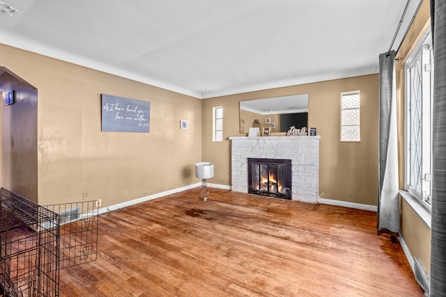 unfurnished living room featuring hardwood / wood-style floors and a stone fireplace