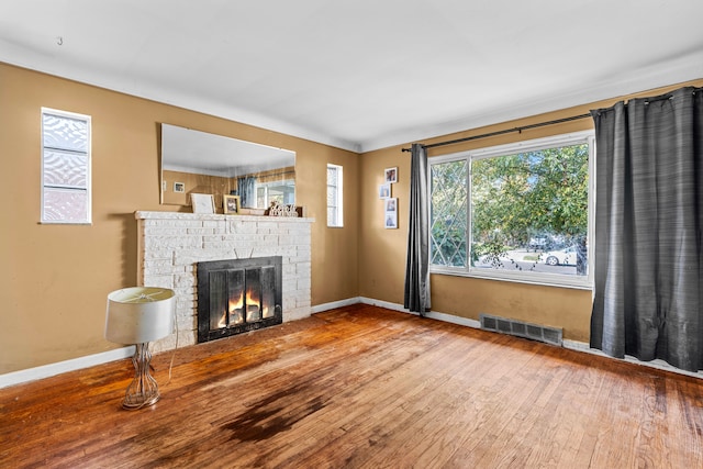 unfurnished living room featuring a wealth of natural light and hardwood / wood-style flooring