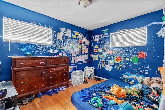 bedroom with light hardwood / wood-style floors and multiple windows