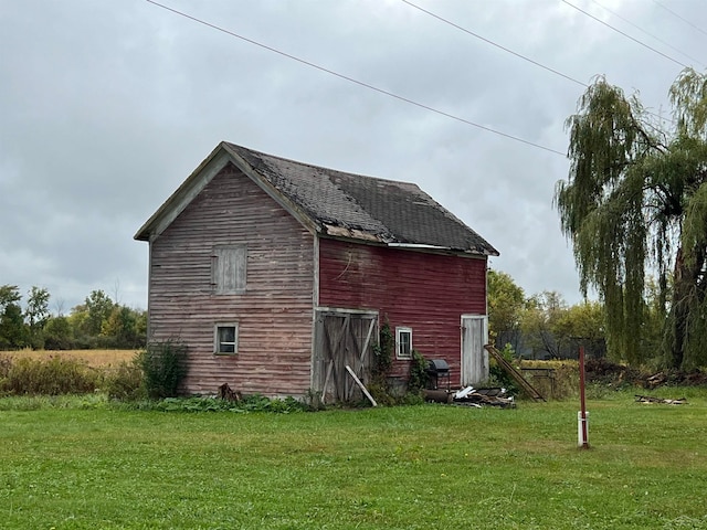 view of property exterior featuring a yard and an outdoor structure