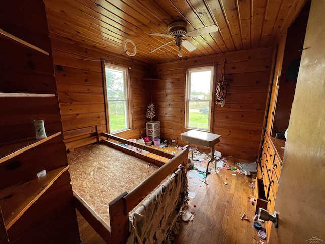 bedroom featuring hardwood / wood-style floors, multiple windows, wooden walls, and wood ceiling