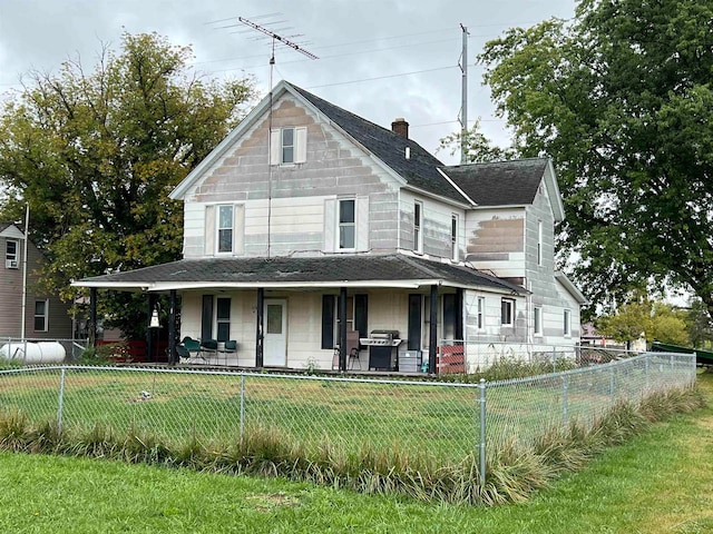 farmhouse featuring covered porch and a front yard