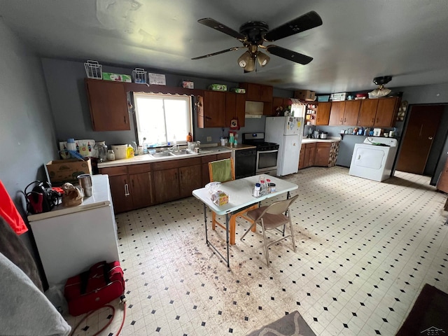 kitchen featuring ceiling fan, washer / clothes dryer, sink, stainless steel electric stove, and white fridge