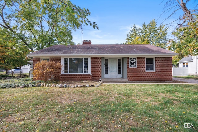 ranch-style house with a front yard, a chimney, fence, and brick siding