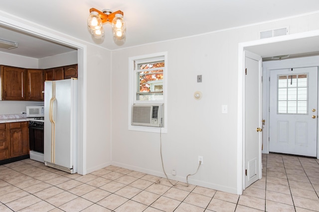 kitchen featuring dark brown cabinetry, crown molding, light tile patterned floors, cooling unit, and white appliances