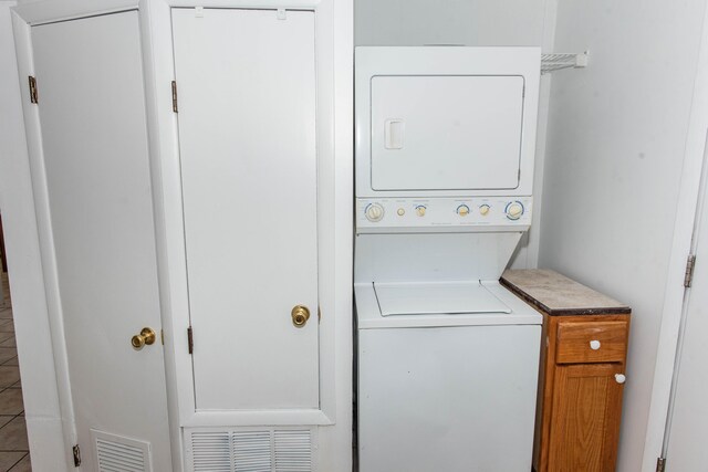 clothes washing area featuring stacked washer and dryer