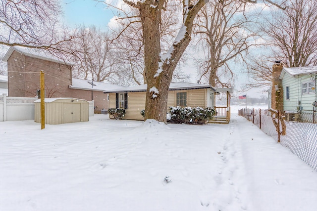 snow covered house with a storage shed