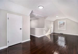 additional living space featuring dark hardwood / wood-style flooring and lofted ceiling