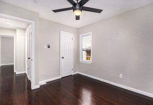 unfurnished room with dark hardwood / wood-style flooring and ceiling fan