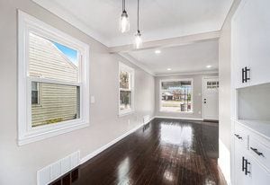 unfurnished living room with crown molding and dark hardwood / wood-style flooring