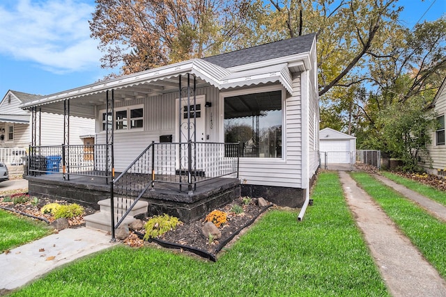 view of front of home with covered porch, a garage, and an outbuilding