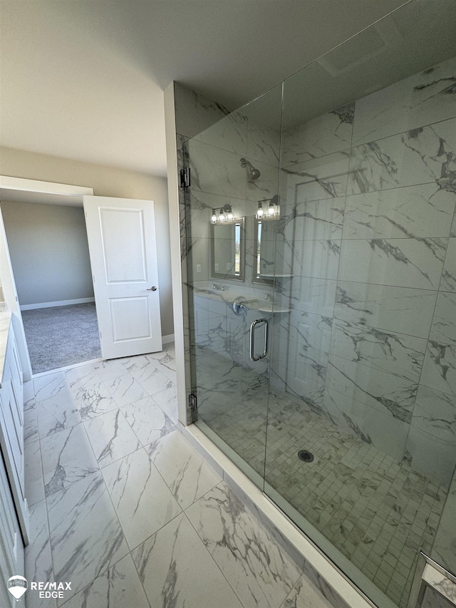 bathroom with marble finish floor, baseboards, and a marble finish shower