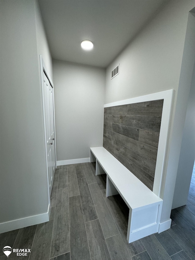 mudroom featuring wood finish floors, visible vents, and baseboards